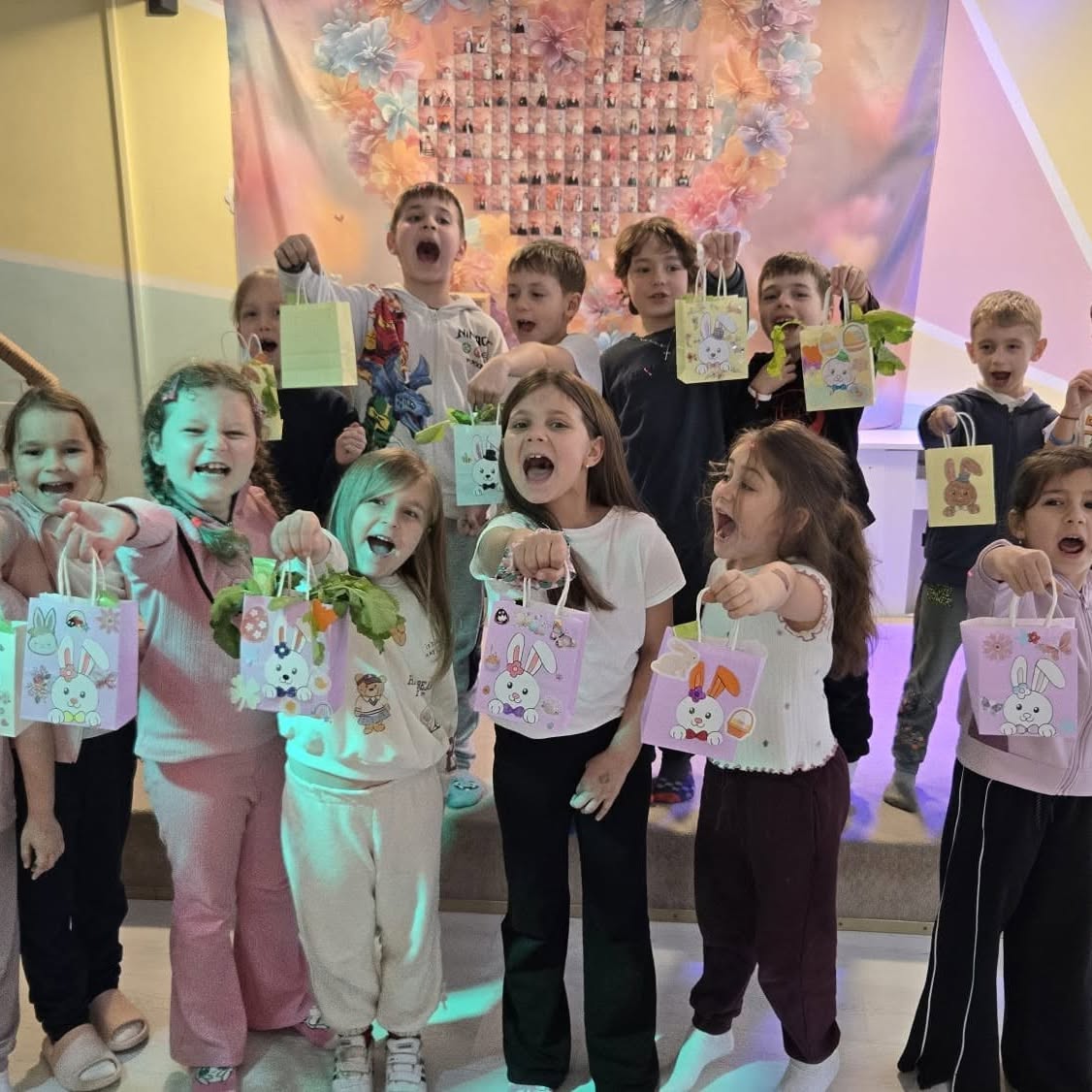 Copii cu pungi decorate de Paște și fire de verdeață